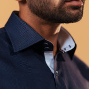 Half side collar view of navy blue Giza dobby shirt on model