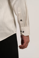 Adjustable dual-button cuff close up on beige striped formal shirt