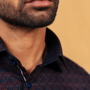 Half side collar view of wine and navy jacquard shirt on model