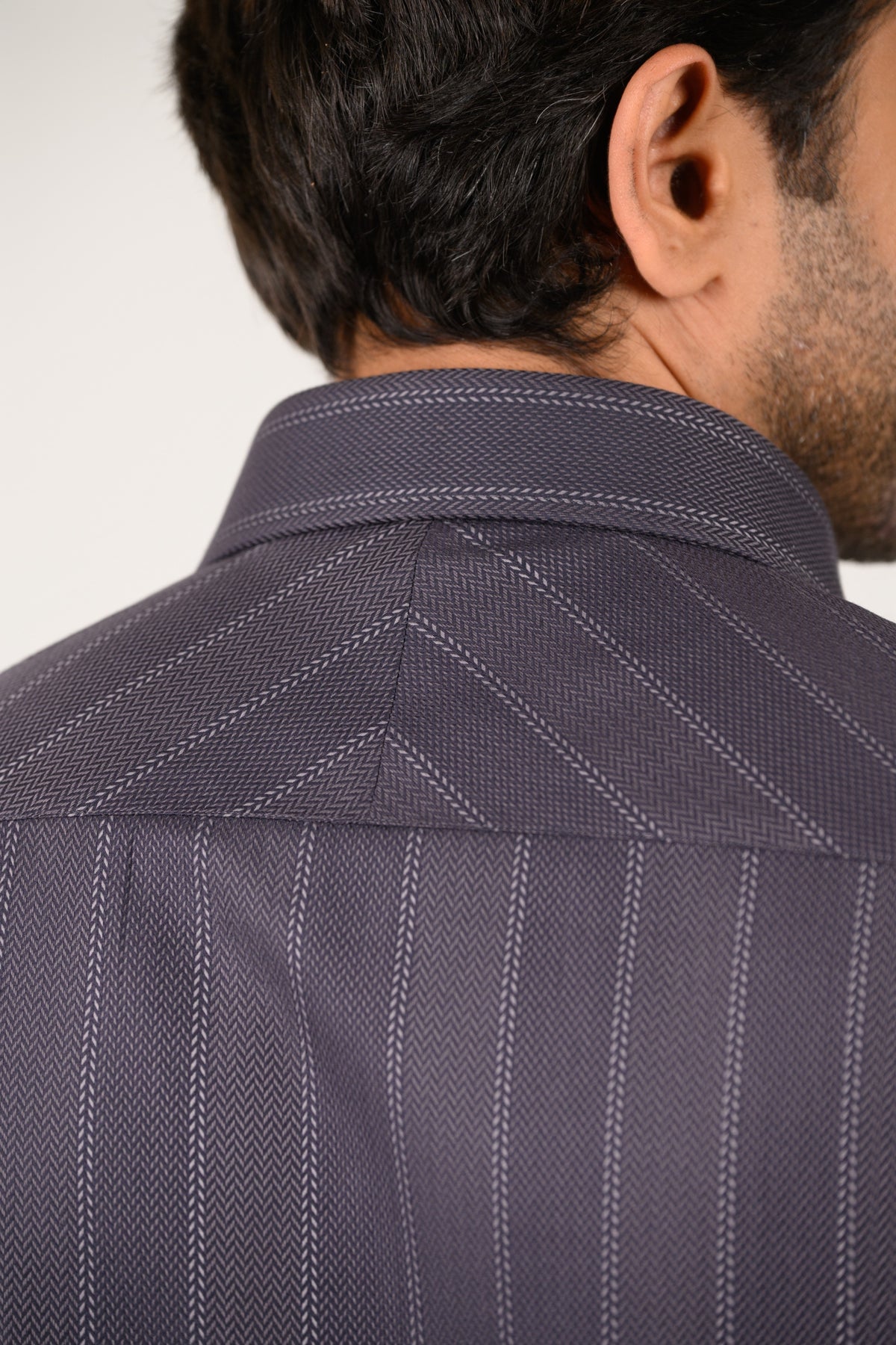 Texture close-up of luxury dark grey Giza satin fabric in herringbone weave