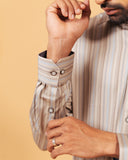 Cuff detail of earth tone satin stripe shirt on model