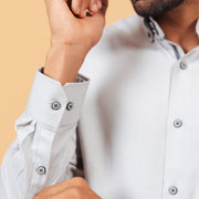 Cuff detail of ivory herringbone shirt on model