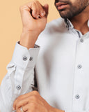 Cuff detail of ivory herringbone shirt on model