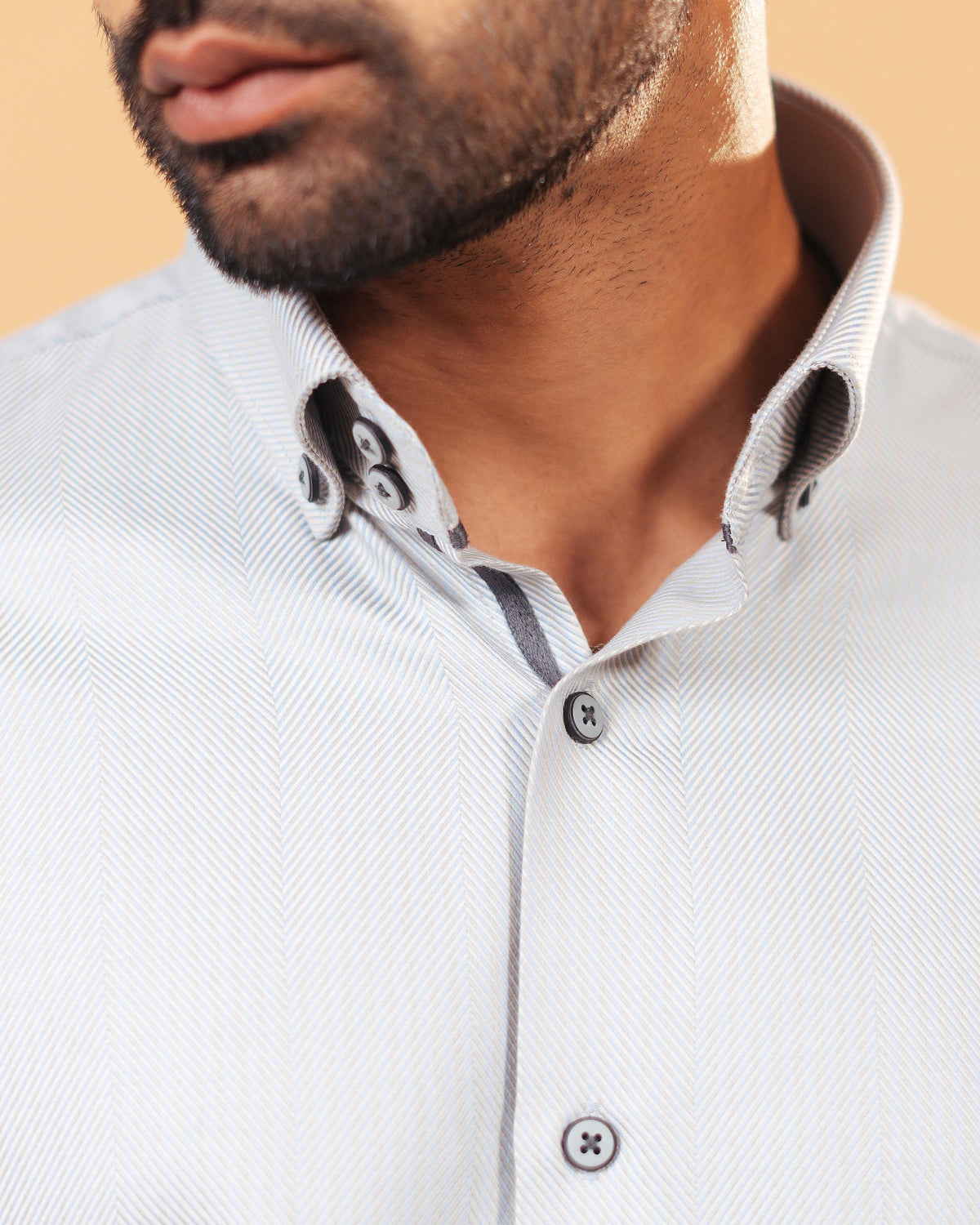 Model wearing ivory herringbone shirt front zoomed collar view