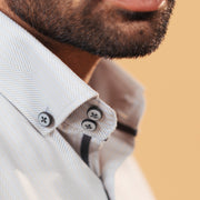 Half side collar view of ivory herringbone shirt on model