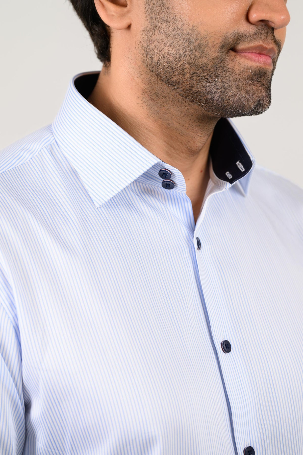 Light blue pinstripe shirt close-up with double-button collar and black collar tape