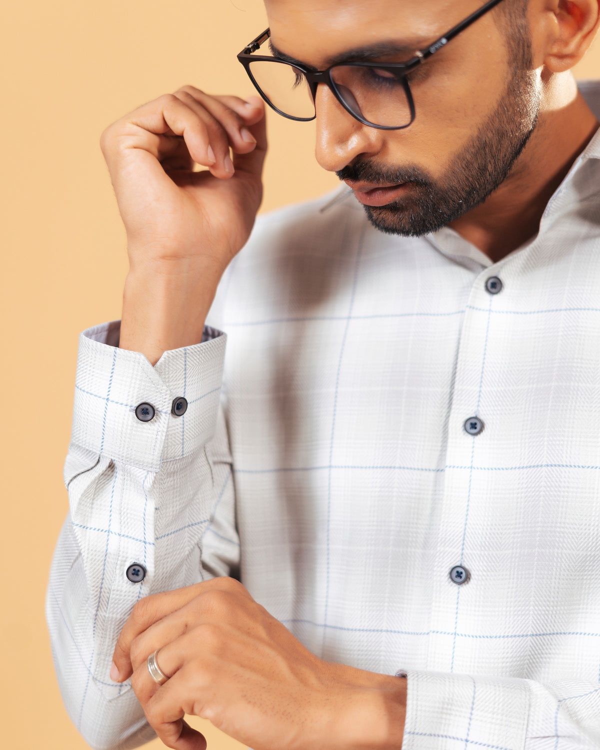 Cuff detail of light grey windowpane twill shirt on model