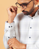 Cuff detail of light grey windowpane twill shirt on model