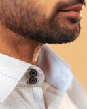 Half side collar view of light grey windowpane twill shirt on model