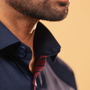 Placket detail of navy blue Giza satin shirt on model