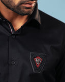 Embroidered signature patch detail of black twill shirt
