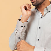 Cuff detail of olive and white Oxford houndstooth shirt on model