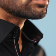 Half side collar view of black twill leather wolf patch shirt on model