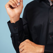 Cuff detail of black twill shirt on model