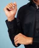 Cuff detail of black twill shirt on model
