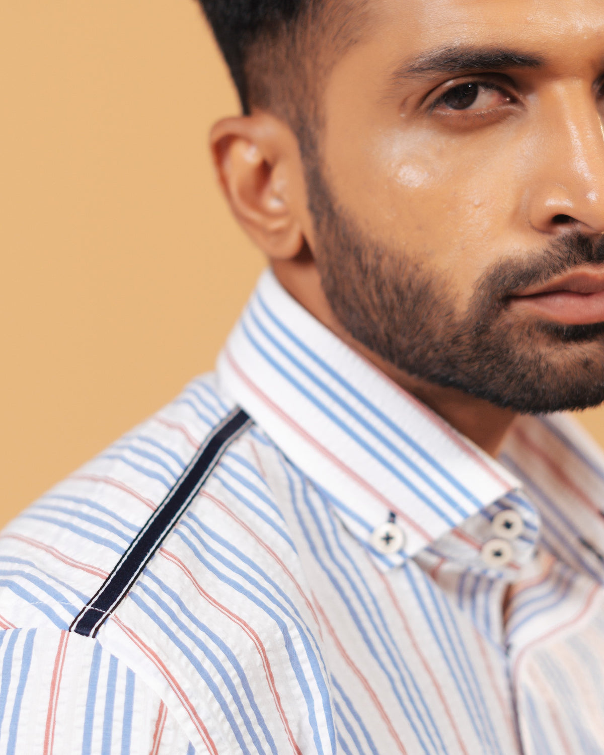 Shoulder view of white seersucker striped shirt on model